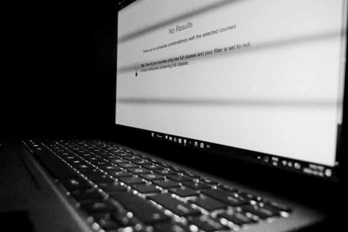 The screen of a computer that showcases a “No Result” message; signalling the inability of adding two courses into the student’s schedule due to a time conflict. The photo is black and white