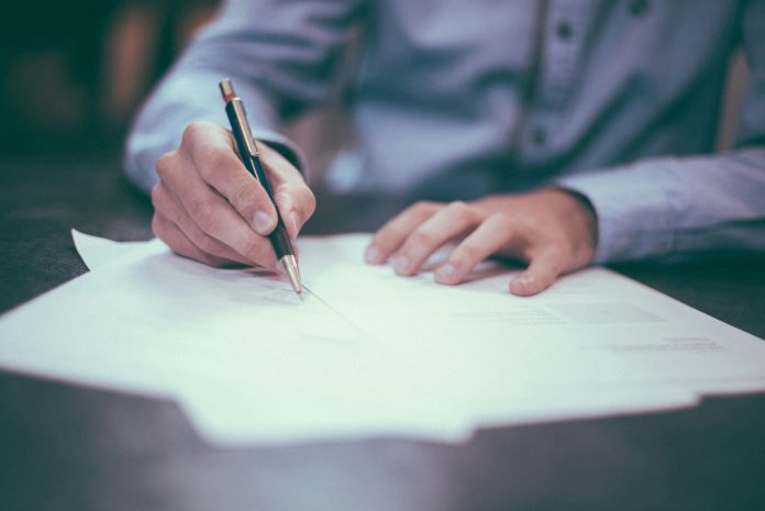 a photo of a person drafting a letter by hand.