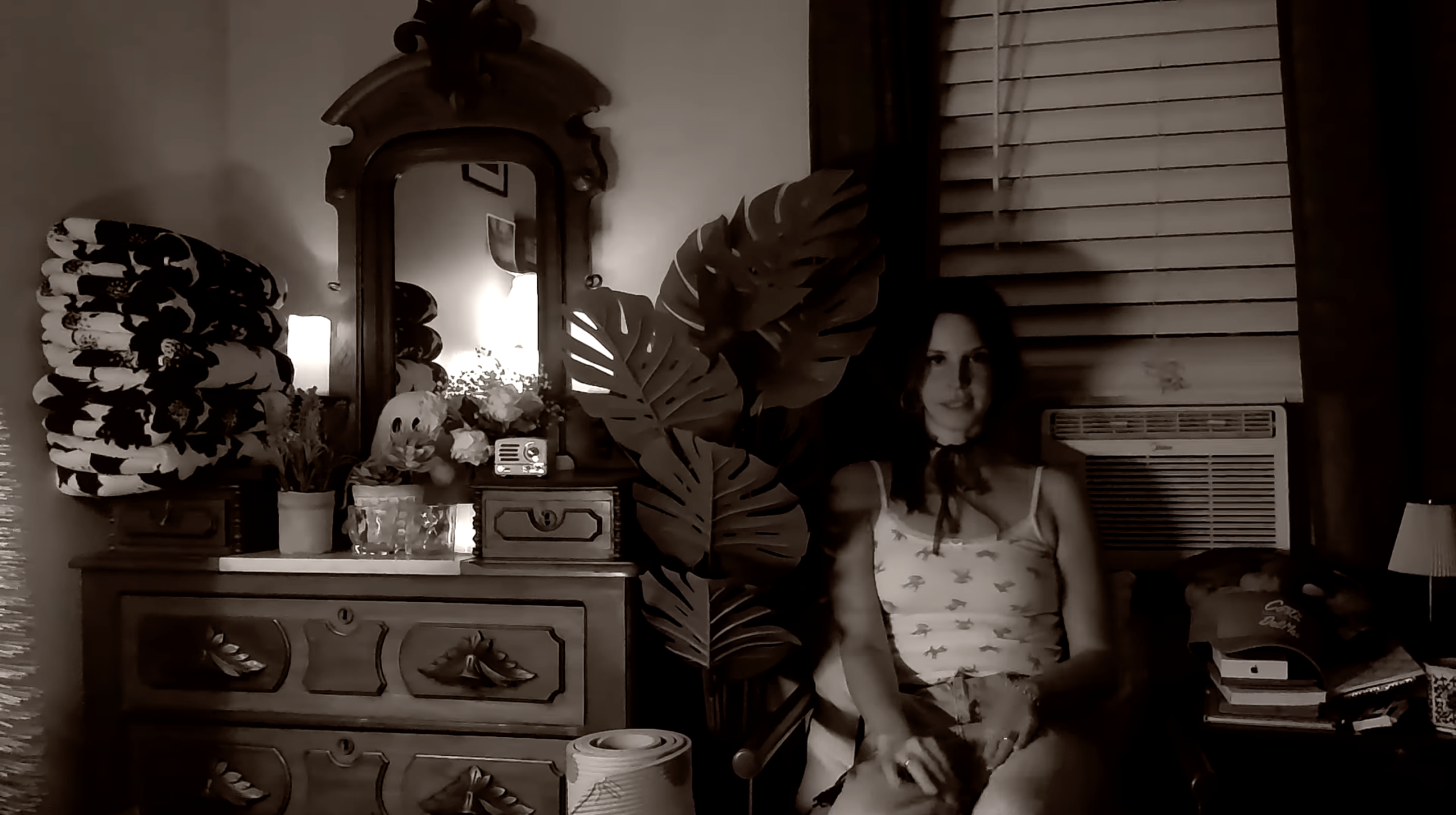 Lana Del Rey sits comfortably on top of a chair.