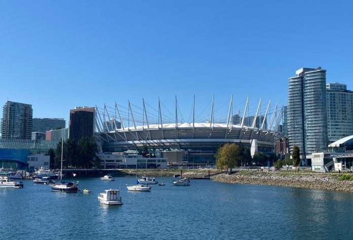 The outside of BC Place and False Creek are pictured on a bright sunny day.