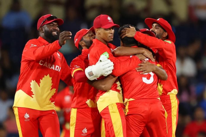 a photo of Canada’s cricket team celebrating in a group hug.