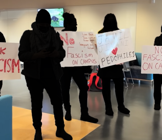 Community members concerned about Conservative event at SFU Protestors holding up signs