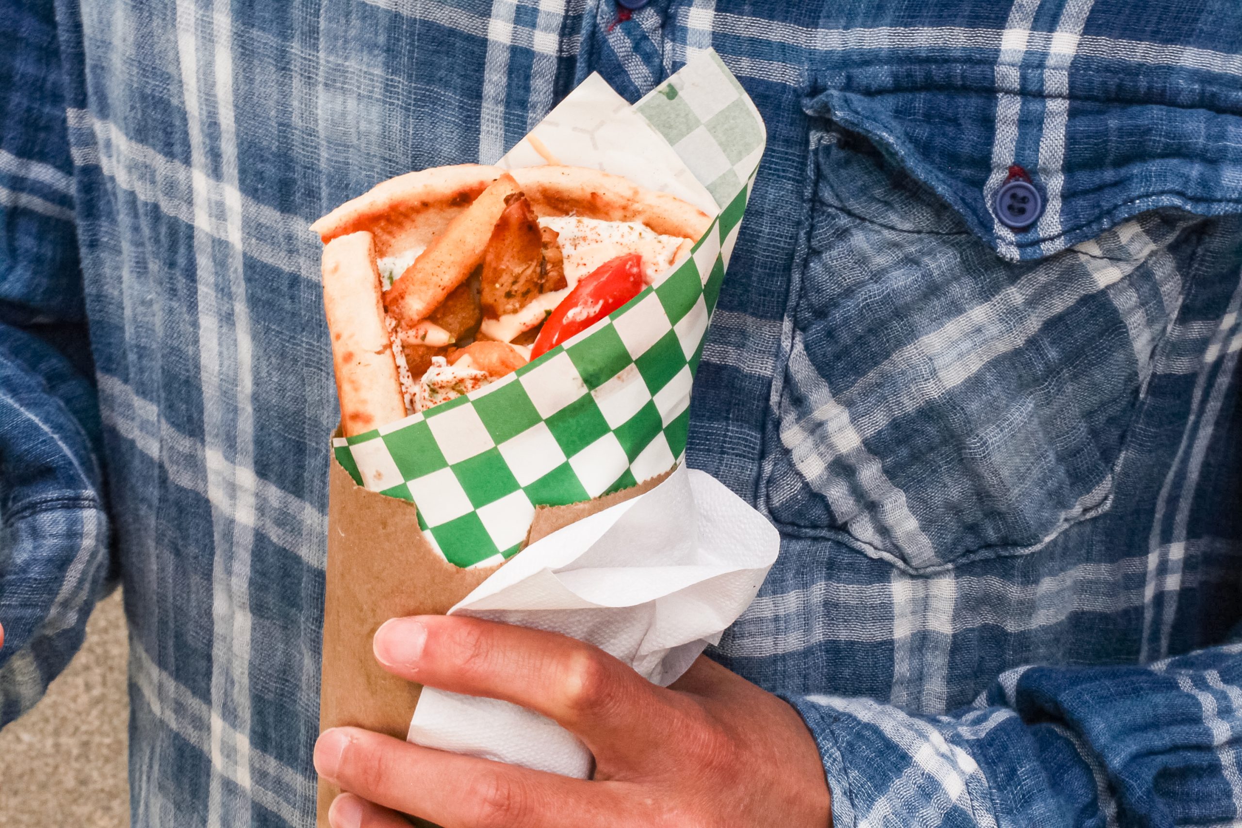 A photo of a chicken wrap in a person’s hands