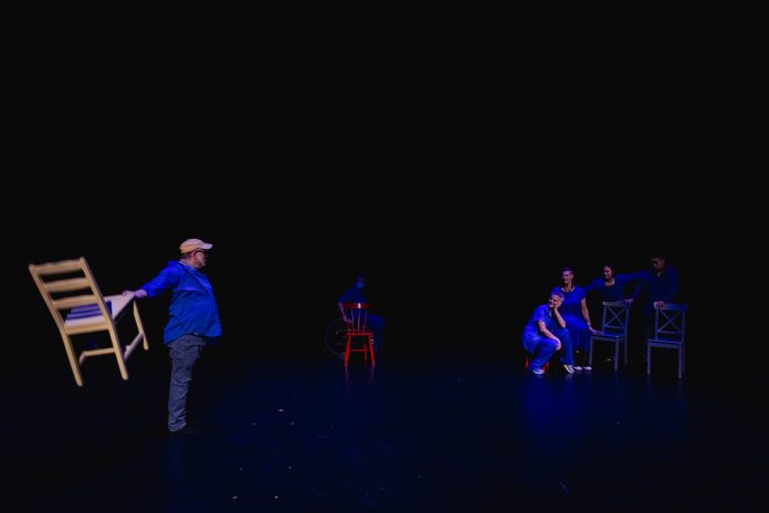 A photo fo Casseiopia mid-performance in a dimly-lit theatre setting
