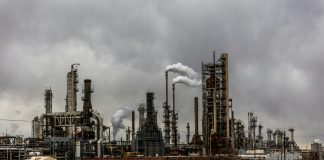 Indigenous Peoples shouldn’t be made to fight for their rights again and again Picture of an oil refinery or upgrader with metal piping, smoke or steam rising from exhaust towers, and chainlinked fencing around the perimeter.