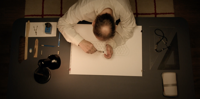 A still from the movie of Hache drawing one of his geometric shapes