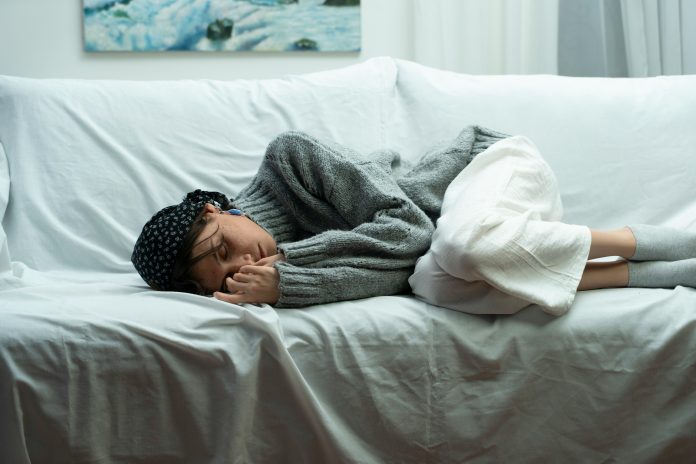 Person curled up sleeping on a couch