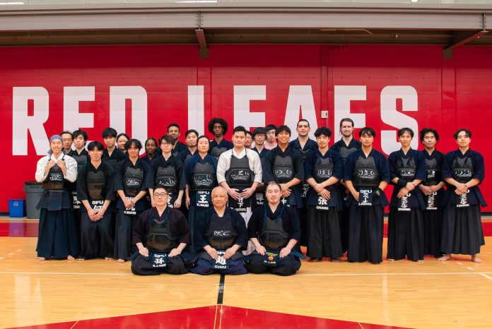 Picture of the SFU Kendo team in uniform at the SFU gym
