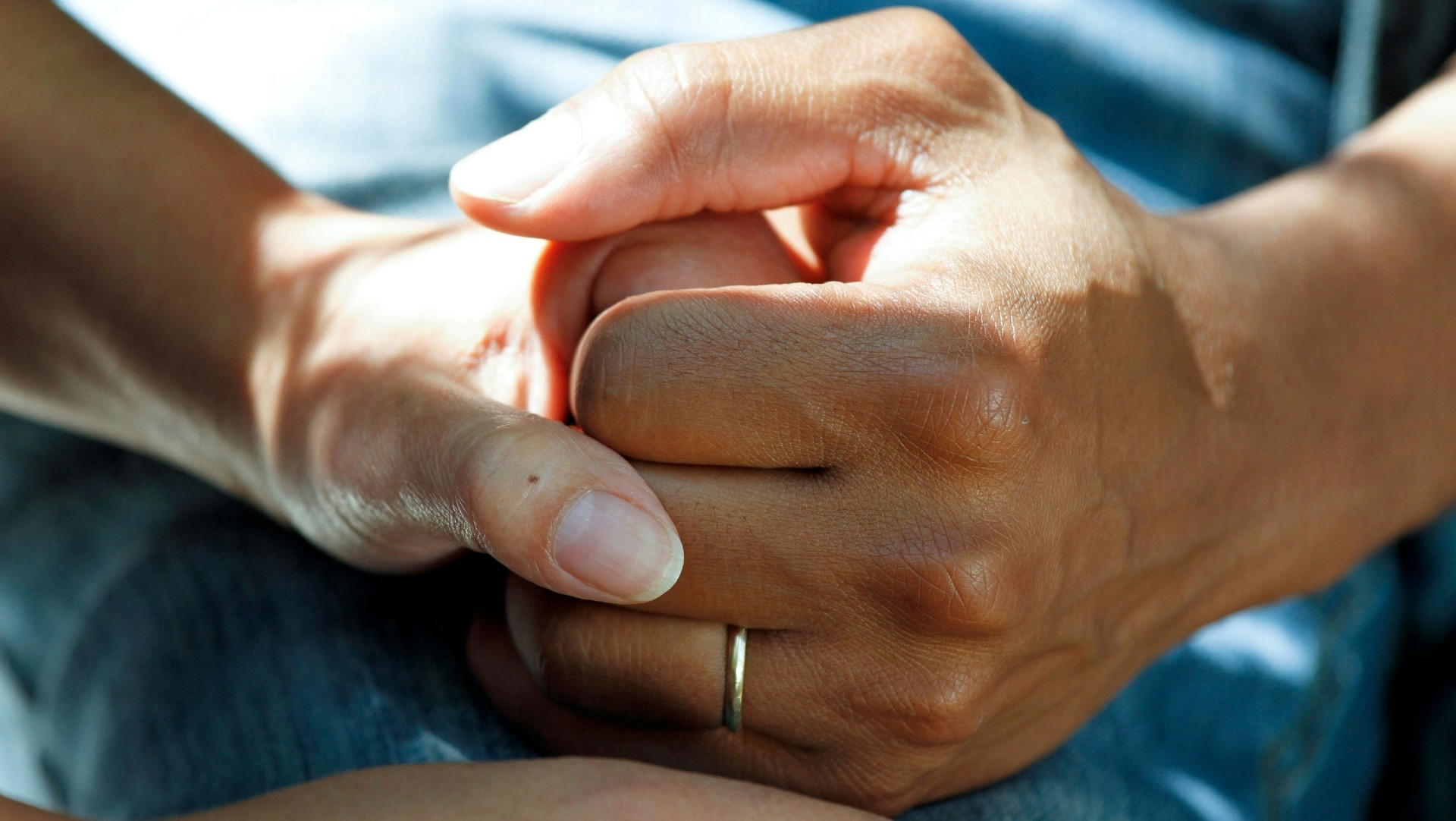 Close-up of a hand holding another person’s hand.