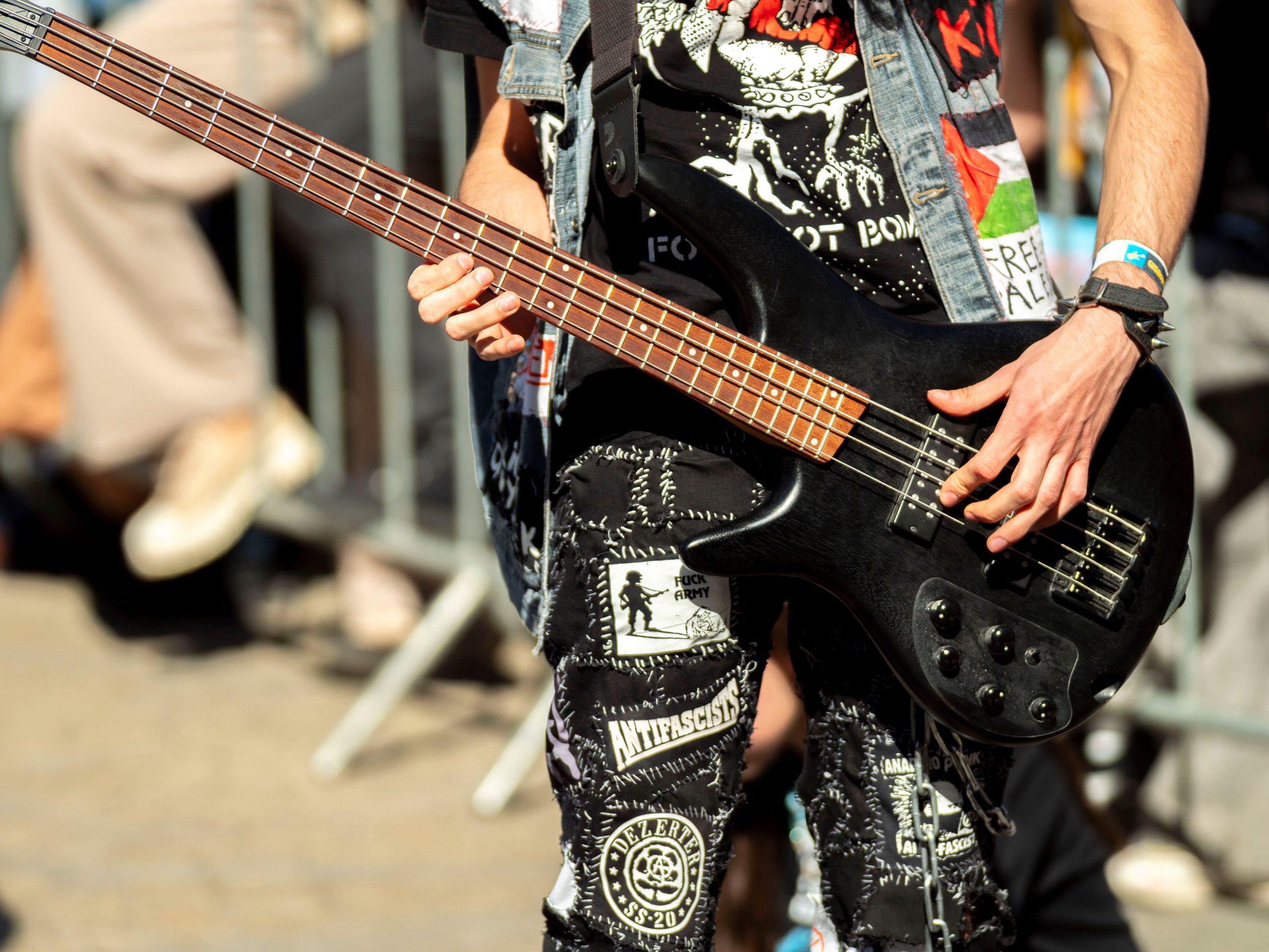 A photo of someone holding an electric guitar at an outdoor music venue